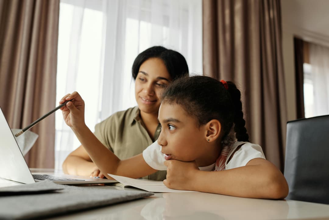 Parent and child learning together at a laptop