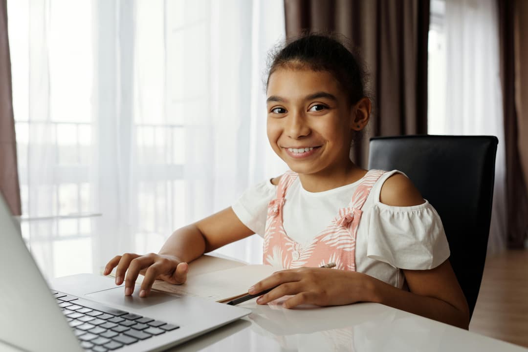 Student smiling at laptop ready to learn online