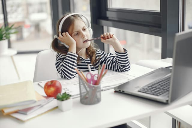 Child learning at home with headphones