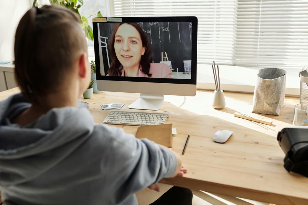 Child learning with a teacher through a video call