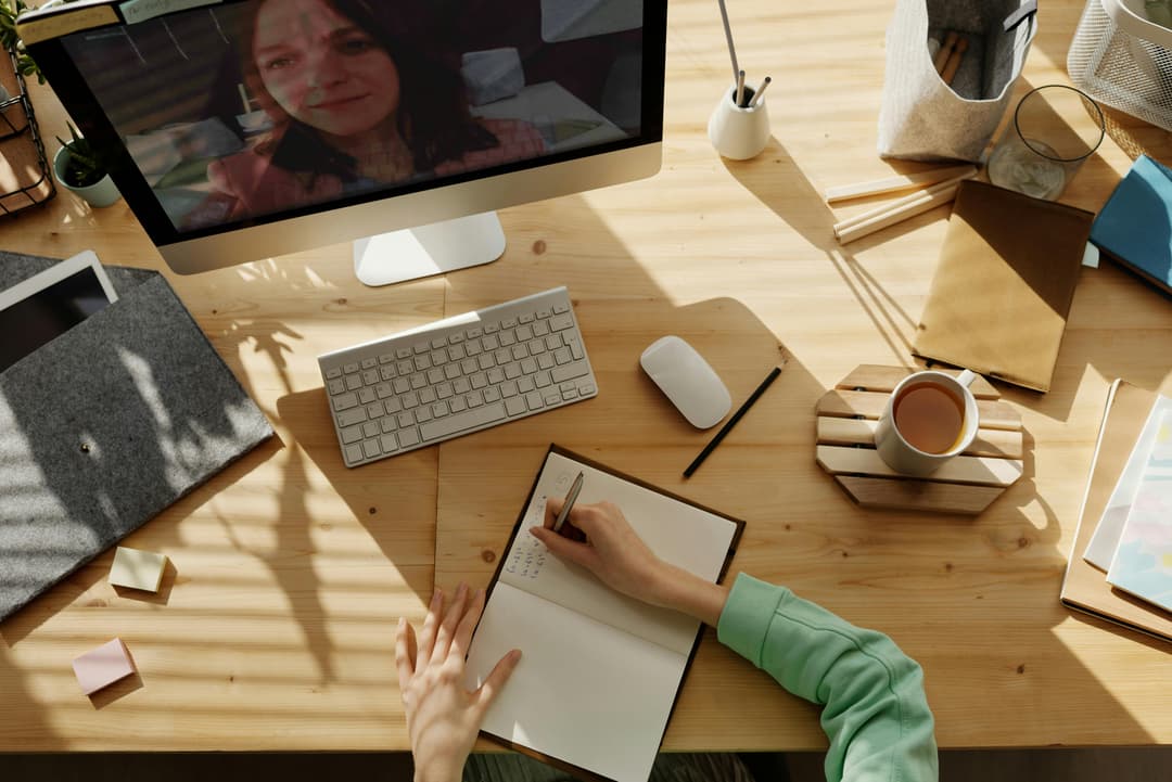 Student taking notes during a virtual learning session