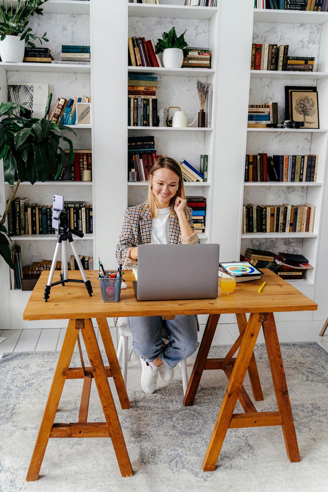 Educator teaching online from a home office with bookshelves